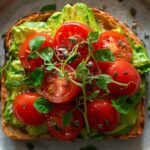 Avocado toast on whole grain bread with cherry tomatoes, hemp seeds, and microgreens — healthy low-sugar breakfast idea for busy mornings, perfect for meal prep and clean eating