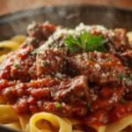 Hearty short rib ragu with pappardelle pasta, rich tomato sauce, and Parmesan garnish – comforting homemade Italian meal recipe.