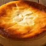 “whole burnt basque cheesecake loaf with caramelized top on wooden table”