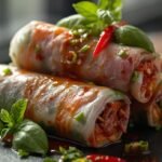 "Close-up of juicy Thai Basil Beef Rolls with fresh basil leaves and glossy sauce, captured in natural light."