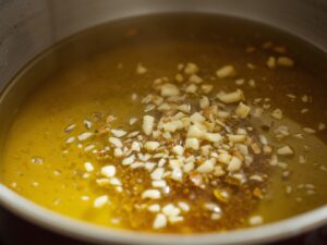 Vegetable oil heating with garlic and ginger in a large pot