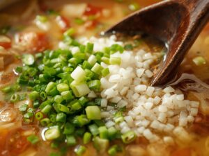 Adding green onions and rice vinegar to soup